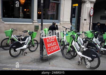 Molte eBike a noleggio Lime sono parcheggiate insieme nella strada della City of London, il quartiere finanziario della capitale, l'11 gennaio 2024, a Londra, in Inghilterra. Foto Stock