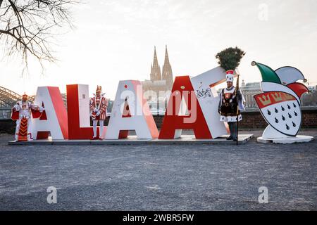 Il triumvirato della società carnevalesca Altgemeinde Rodenkirchen si trova di fronte al lettering Alaaf alto due metri nel quartiere Deutz, nel b Foto Stock