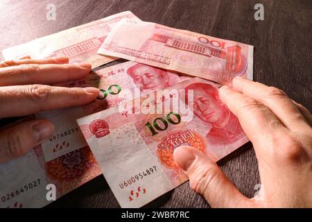 Contando soldi, yuan cinese in mano. Concetto di finanza ed economia cinese. Messa a fuoco selettiva. Foto Stock