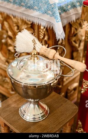 Un'ampia ciotola d'argento e un irrigatore per la consacrazione nella chiesa. Foto Stock