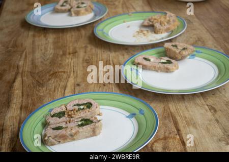 fette di polpettone ripieno di spinaci allineate in un piatto bianco Foto Stock