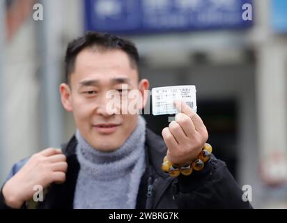 Pechino, provincia cinese di Guizhou. 12 gennaio 2024. Un passeggero mostra il suo biglietto del treno per l'imminente corsa di viaggio del Festival di Primavera, nella città di Kaili di Qiandongnan Miao e nella prefettura autonoma di Dong, nella provincia di Guizhou nel sud-ovest della Cina, 12 gennaio 2024. PER ANDARE CON XINHUA TITOLI DI JAN. 12, 2024 crediti: Wu Jibin/Xinhua/Alamy Live News Foto Stock