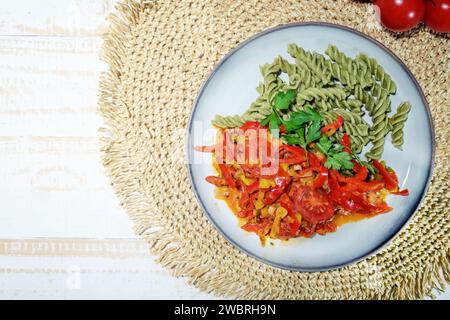 Tagliatelle di legumi verdi a base di fagioli mung e ragù vegetale di peperoni e pomodori, pasto vegano senza glutine con molte proteine, vitamine e vi Foto Stock