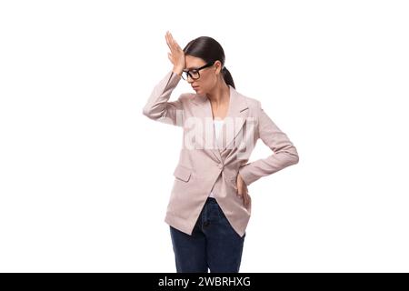 giovane donna bruna europea snella e perplessa si erge con cura su uno sfondo bianco Foto Stock
