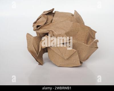 Palla di carta schiacciata su sfondo di carta marrone Foto Stock