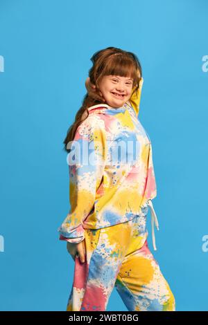 Campagne di sensibilizzazione sulla salute mentale. Ragazza adolescente con sindrome di Down sullo sfondo blu dello studio Foto Stock