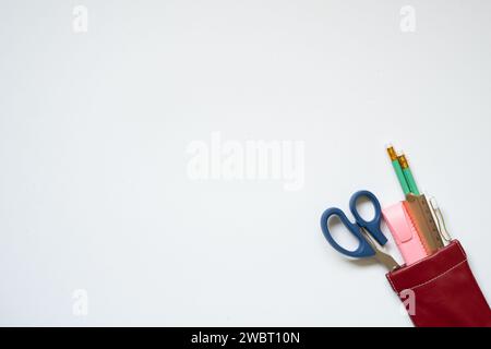 Fornitura per scrittura. Matita, penna, righello, evidenziatore, forbici in astuccio isolato su sfondo bianco della scrivania. vista dall'alto, spazio di copia Foto Stock