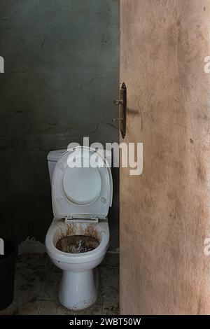 Un bagno sporco macchiato in un bagno pubblico abbandonato, Libano. Foto Stock