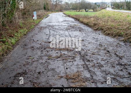 Cookham, Regno Unito. 6 gennaio 2024. Residui di acqua alluvionale lasciati sulla strada dopo l'allagamento. La strada principale B4447 attraverso Cookham Moor nel villaggio di Cookham, Berkshire, rimane chiusa a causa delle inondazioni dal Tamigi. La vecchia strada accanto ad essa chiamata Causeway è aperta per ore prestabilite per consentire a un numero limitato di veicoli di attraversare il ponte lì. Credito: Maureen McLean/Alamy Live News Foto Stock