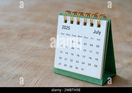 Luglio 2025 tavolo con calendario su scrivania in legno con spazio personalizzabile per il testo. Informazioni su spazio di copia e calendario. Foto Stock
