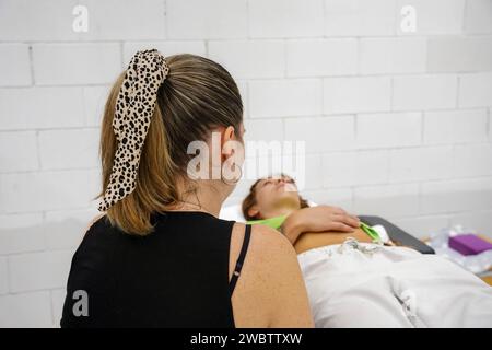 Reiki guaritore professionista che fa massaggio trattamento a giovane donna in centro benessere. Foto Stock