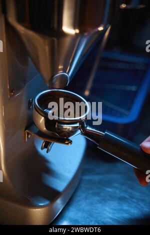 Professional meccanismo di macinazione. Barista macinare i chicchi di caffè  utilizzando la macchina per il caffè. Macinino da caffè macinazione fagioli  arrosto in polvere. Caffè macinato fresco in portafilter. Barista fa  espresso