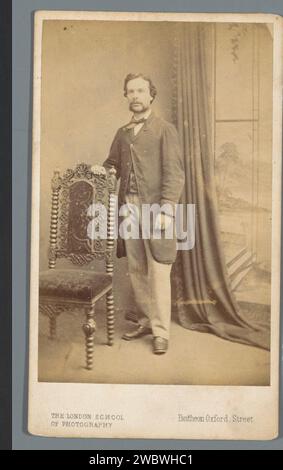 Ritratto di un uomo sconosciuto, in piedi dietro una sedia, S. Prout Newcombe, 1853 - 1870 Fotografia. Visita il giornale di Card London. gli albumi di cartone stampano persone storiche. uomo adulto. sedia Foto Stock