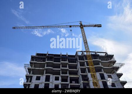 Costruzione di un nuovo edificio residenziale con uso di gru a torre contro Blue Sky. Immobili, edifici residenziali sviluppo urbano ad uso misto C Foto Stock