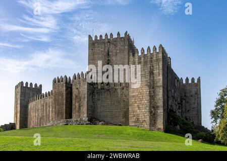 Castello di Guimaraes a Guimaraes, Portogallo, un castello romanico in cima a una collina, fondato nel 1000 e luogo di nascita di Afonso Henriques contro un cielo azzurro Foto Stock