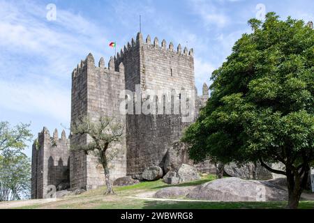 Castello di Guimaraes a Guimaraes, Portogallo, un castello romanico in cima a una collina, fondato nel 1000 e luogo di nascita di Afonso Henriques contro un cielo azzurro Foto Stock