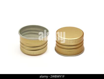 Tappo per flacone in metallo dorato su due lati isolato su sfondo bianco. Foto Stock