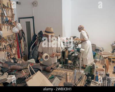 Due persone in piedi in una stanza piena di un assortimento disorganizzato e caotico di oggetti. Foto Stock