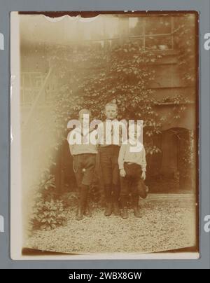 Ritratto di tre ragazzi sconosciuti in un giardino, Anonymous, c. 1905 - c. 1910 Fotografia Olanda bambino di supporto fotografico (bambino tra il bambino e la giovinezza). nel cortile Foto Stock