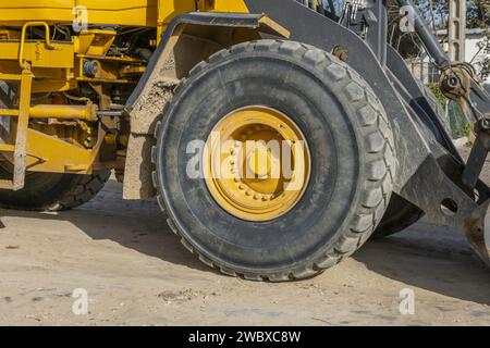 Un grande pneumatico in gomma sulla ruota di un bulldozer per lavori civili Foto Stock