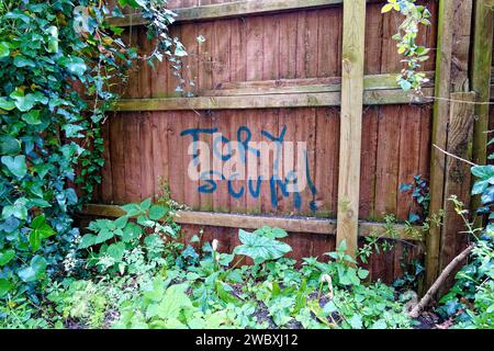 Warminster, Wiltshire, Regno Unito - 6 giugno 2023: Un cartello Tory Scum Graffiti dipinto su una recinzione del giardino accanto a un sentiero pubblico Foto Stock