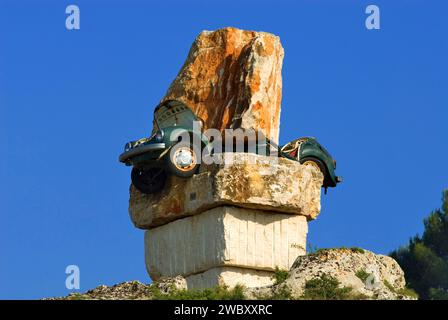 Arte nel sud Italia, uno scarabeo VW verde completamente schiacciato tra enormi massi, Italia, Europa Foto Stock