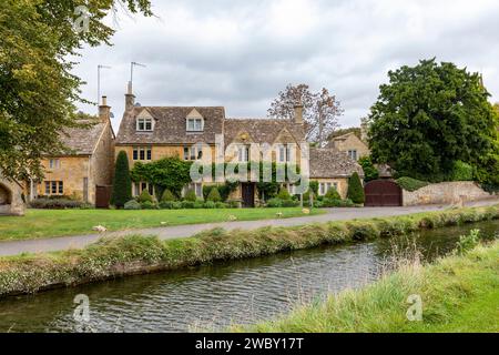 Lower Slaughter Village Cotswolds Inghilterra e filari di cottage e case in pietra color miele inglesi accanto al River Eye, Inghilterra, Regno Unito, autunno 2023 Foto Stock