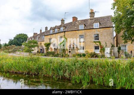 Lower Slaughter Village Cotswolds Inghilterra e filari di cottage e case in pietra color miele inglesi accanto al River Eye, Inghilterra, Regno Unito, autunno 2023 Foto Stock