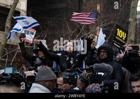 Manhattan, Stati Uniti. 12 gennaio 2024. Una donna ondeggia bandiere di Israele e degli Stati Uniti d'America durante una manifestazione che chiede il rilascio di ostaggi israeliani rapiti da Hamas a Dag Hammarskjold Plaza fuori dal quartier generale delle Nazioni Unite. Il 12 gennaio segna il 100° giorno in cui gli ostaggi sono tenuti in cattività dall'attacco a Israele il 7 ottobre 2023. (Foto di Derek French/SOPA Images/Sipa USA) credito: SIPA USA/Alamy Live News Foto Stock