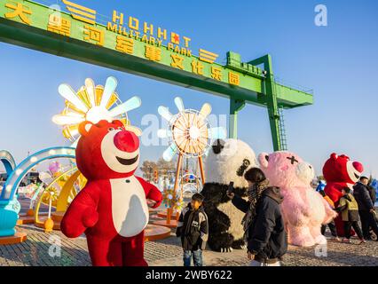 HOHHOT, CINA - 12 GENNAIO 2024 - i visitatori interagiscono con i personaggi dei cartoni animati al 3° Hohhot Happy Ice and Snow Festival di Hohhot, Mongolia interna, chi Foto Stock