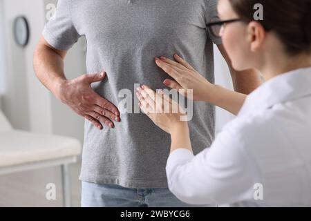 Gastroenterologo che esamina il paziente con dolore allo stomaco in clinica Foto Stock