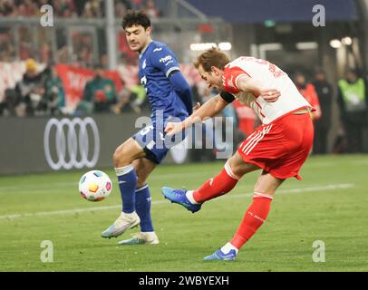 Monaco, Germania. 12 gennaio 2024. Harry Kane (R) del Bayern Monaco spara durante la partita di calcio della Bundesliga di prima divisione tedesca tra il Bayern Monaco e il TSG Hoffenheim a Monaco di Baviera, in Germania, 12 gennaio 2024. Credito: Philippe Ruiz/Xinhua/Alamy Live News Foto Stock