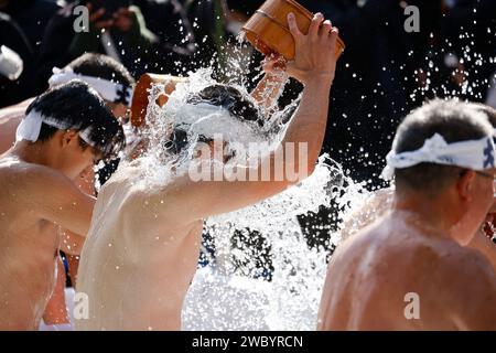 Tokyo, Giappone. 13 gennaio 2024. I partecipanti vestiti solo con lincloth versano acqua fredda su se stessi durante la tradizionale cerimonia di purificazione a freddo (Kanchu-Misogi) presso il Santuario di Kanda Myojin. L'evento annuale incoraggia i partecipanti a sfidare il rituale del bagno di ghiaccio, una cerimonia tradizionale che purifica l'anima e porta fortuna. (Immagine di credito: © Rodrigo Reyes Marin/ZUMA Press Wire) SOLO USO EDITORIALE! Non per USO commerciale! Foto Stock