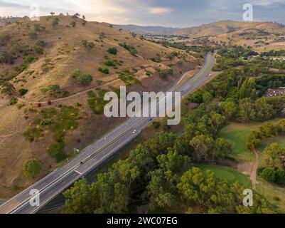 Vista aerea di un'ampia superstrada che corre tra le colline di Gundagai nel nuovo Galles del Sud, Australia Foto Stock