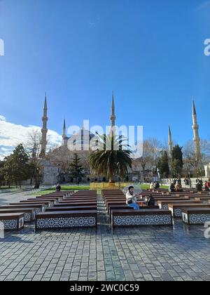 Istanbul, Turchia - 8 gennaio 2024: Un gruppo di persone siede nel cortile della Moschea Blu di Istanbul. Foto Stock