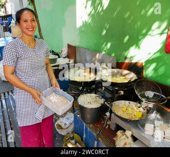 Una donna venditrice di cibo di strada che vende vari tipi di gorengan indonesiano o spuntini fritti di cibo di strada nella parte vecchia della città di Bandung, Giava Occidentale, Indonesia. Foto Stock