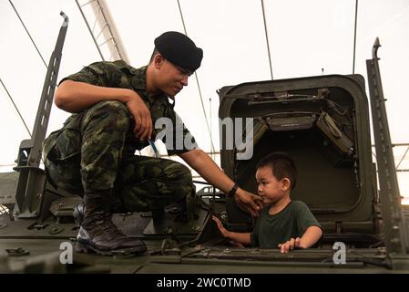 Bangkok, Thailandia. 13 gennaio 2024. Un soldato aiuta un bambino a salire fuori da un carro armato durante la giornata dei bambini in Thailandia presso una base dell'esercito reale tailandese a Bangkok. Credito: SOPA Images Limited/Alamy Live News Foto Stock