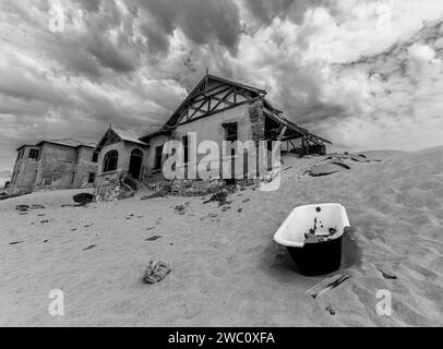 Una vecchia vasca da bagno fuori da una delle molte case abbandonate nella vecchia città fantasma di Kolmanskop, nella Namibia meridionale Foto Stock