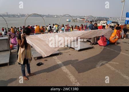 Calcutta, Bengala Occidentale, India. 12 gennaio 2024. Mentre inizia il conto alla rovescia per Makar Sankranti, il campo di transito di Gangasagar Mela a Calcutta assiste a una serie di emozioni. Sadhus si impegna in serene preghiere, i pellegrini emanano eccitazione e i devoti eseguono ferventi rituali. Le famiglie salutano in lacrime, mentre gli sforzi logistici si intensificano per una transizione senza soluzione di continuità. L'atmosfera è una miscela di spiritualità, anticipazione e connessioni emotive con l'avvicinarsi della Mela il 14 e 15 gennaio 2024. (Immagine di credito: © Biswarup Ganguly/Pacific Press via ZUMA Press Wire) SOLO USO EDITORIALE! Non per Foto Stock