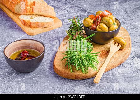 Un primo piano di pane appena affettato, con olive e acciughe Foto Stock