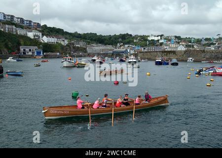 L'equipaggio di Dew of the Sea si dirige verso la partenza del concerto di pilota femminile alla regata, Mevagissey, Cornovaglia, Inghilterra, Regno Unito Foto Stock