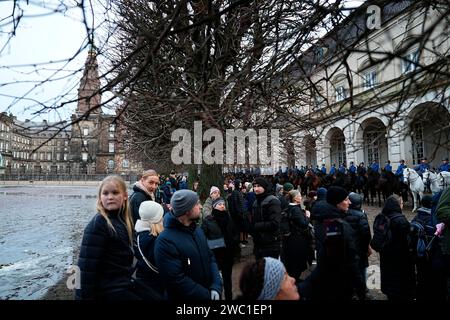 I soldati del reggimento ussari della guardia danese cavalcano fuori dalle scuderie reali del palazzo di Christiansborg mentre provano per domenica, quando la regina Margrethe II abdicò e suo figlio maggiore, il principe ereditario Frederik, salì al trono, a Copenaghen in Danimarca, sabato 13 gennaio 2024, Foto Stock