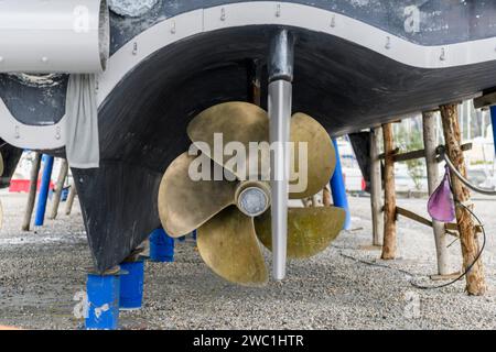 Elica dello yacht. Elica a lama fissa e timone. Yacht a terra nel cantiere di riparazione delle navi. Foto Stock