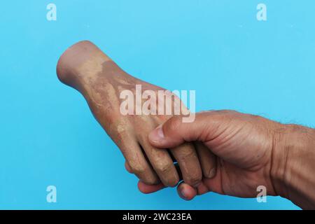 Una vera mano di plastica che tocca l'uomo dal manichino. Foto Stock