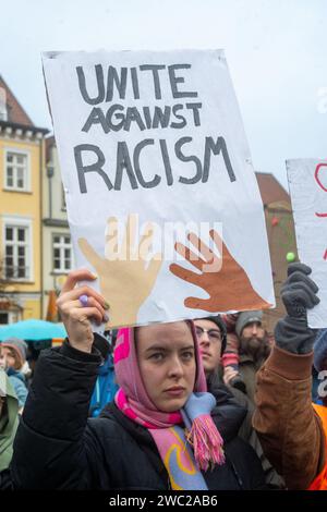 Greifswald, Germania. 13 gennaio 2024. Secondo la polizia, 1.200 persone hanno manifestato contro il razzismo nella piazza del mercato di Greifswald di fronte al municipio alla luce dei recenti attacchi nella città. Con il motto "Mostra la tua faccia - contro il razzismo”, i residenti di Greifswald hanno parlato in una manifestazione di sabato pomeriggio delle loro esperienze nella vita quotidiana, del loro lavoro, dei loro studi e del loro impegno sociale. Crediti: Stefan Sauer/dpa/Alamy Live News Foto Stock