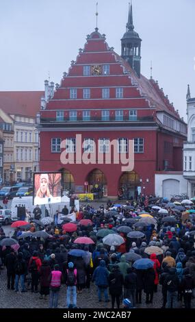 Greifswald, Germania. 13 gennaio 2024. Secondo la polizia, 1.200 persone hanno manifestato contro il razzismo nella piazza del mercato di Greifswald di fronte al municipio alla luce dei recenti attacchi nella città. Con il motto "Mostra la tua faccia - contro il razzismo”, i residenti di Greifswald hanno parlato in una manifestazione di sabato pomeriggio delle loro esperienze nella vita quotidiana, del loro lavoro, dei loro studi e del loro impegno sociale. Crediti: Stefan Sauer/dpa/Alamy Live News Foto Stock