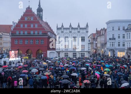 Greifswald, Germania. 13 gennaio 2024. Secondo la polizia, 1.200 persone hanno manifestato contro il razzismo nella piazza del mercato di Greifswald di fronte al municipio alla luce dei recenti attacchi nella città. Con il motto "Mostra la tua faccia - contro il razzismo”, i residenti di Greifswald hanno parlato in una manifestazione di sabato pomeriggio delle loro esperienze nella vita quotidiana, del loro lavoro, dei loro studi e del loro impegno sociale. Crediti: Stefan Sauer/dpa/Alamy Live News Foto Stock