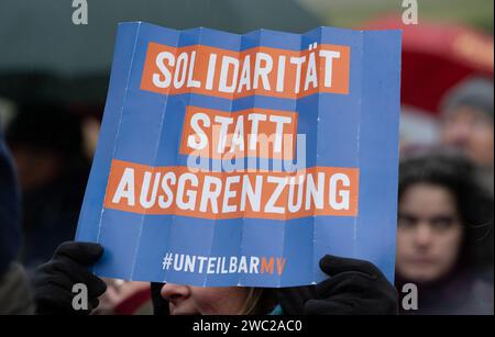 Greifswald, Germania. 13 gennaio 2024. Secondo la polizia, 1.200 persone hanno manifestato contro il razzismo nella piazza del mercato di Greifswald di fronte al municipio alla luce dei recenti attacchi nella città. Con il motto "Mostra la tua faccia - contro il razzismo”, i residenti di Greifswald hanno parlato in una manifestazione di sabato pomeriggio delle loro esperienze nella vita quotidiana, del loro lavoro, dei loro studi e del loro impegno sociale. Crediti: Stefan Sauer/dpa/Alamy Live News Foto Stock