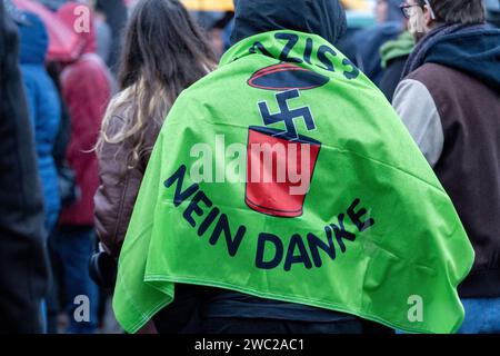 Greifswald, Germania. 13 gennaio 2024. Secondo la polizia, 1.200 persone hanno manifestato contro il razzismo nella piazza del mercato di Greifswald di fronte al municipio alla luce dei recenti attacchi nella città. Con il motto "Mostra la tua faccia - contro il razzismo”, i residenti di Greifswald hanno parlato in una manifestazione di sabato pomeriggio delle loro esperienze nella vita quotidiana, del loro lavoro, dei loro studi e del loro impegno sociale. Crediti: Stefan Sauer/dpa/Alamy Live News Foto Stock