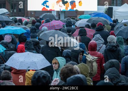 Greifswald, Germania. 13 gennaio 2024. Secondo la polizia, 1.200 persone hanno manifestato contro il razzismo nella piazza del mercato di Greifswald di fronte al municipio alla luce dei recenti attacchi nella città. Con il motto "Mostra la tua faccia - contro il razzismo”, i residenti di Greifswald hanno parlato in una manifestazione di sabato pomeriggio delle loro esperienze nella vita quotidiana, del loro lavoro, dei loro studi e del loro impegno sociale. Crediti: Stefan Sauer/dpa/Alamy Live News Foto Stock